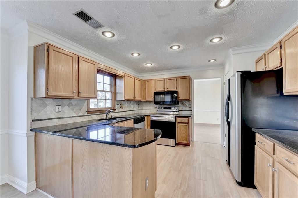 3945 Genoa Court Duluth, GA 30096 - Photo 27 of 64 a kitchen with stainless steel appliances granite countertop a refrigerator sink and stove