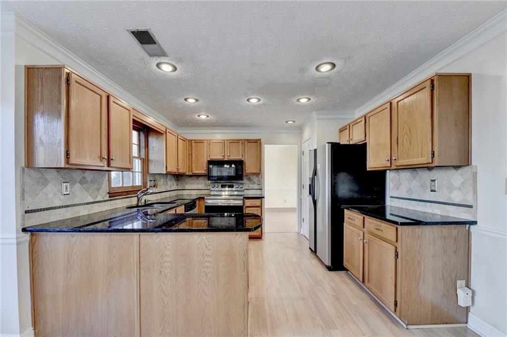 3945 Genoa Court Duluth, GA 30096 - Photo 28 of 64 a kitchen with stainless steel appliances granite countertop a refrigerator stove microwave and sink