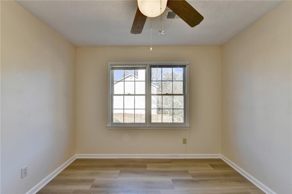 3945 Genoa Court Duluth, GA 30096 - Photo 54 of 64 an empty room with wooden floor chandelier fan and windows