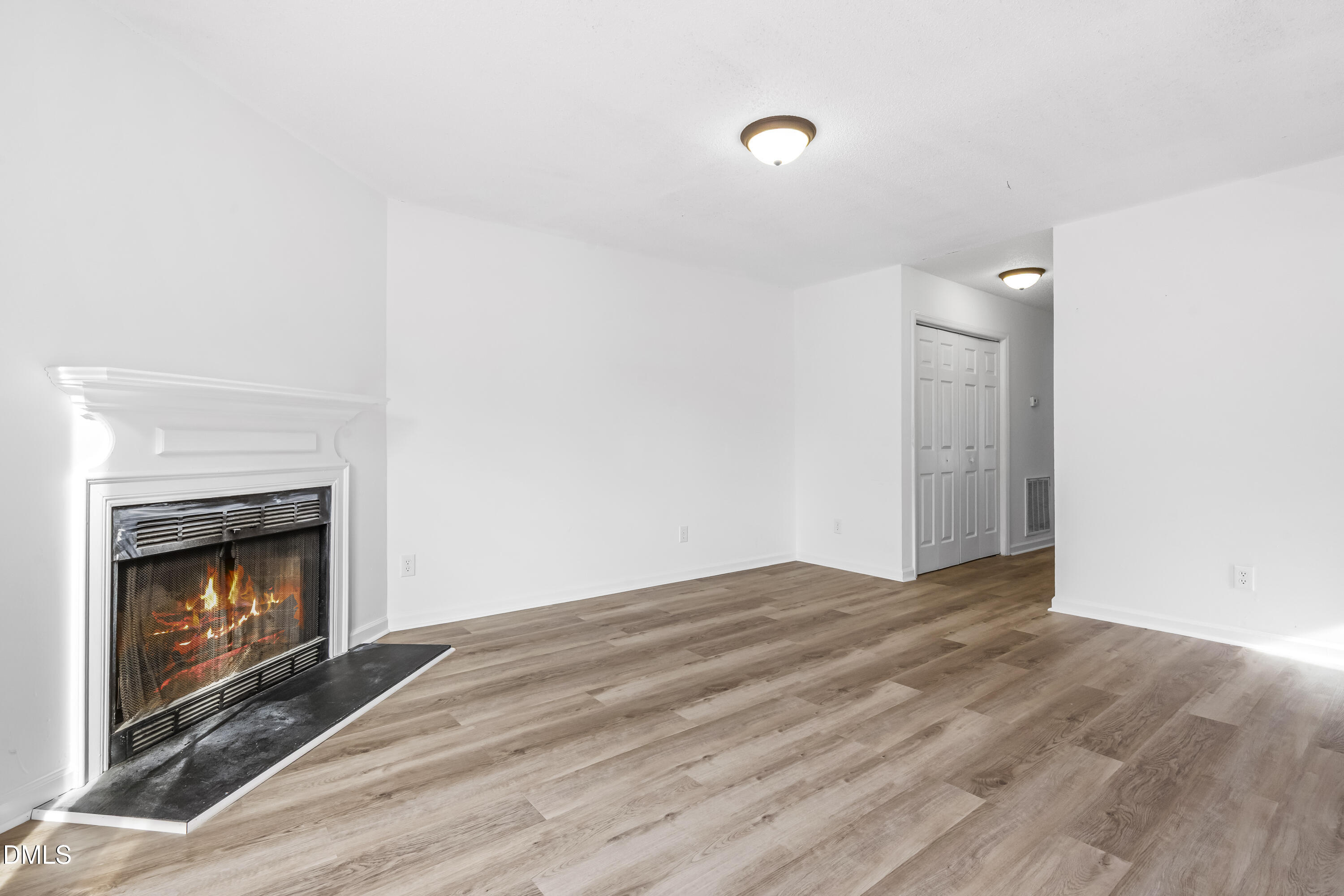 8029 Perry Creek Road Raleigh, NC 27616 - Photo 12 of 27 a view of an empty room with wooden floor and fireplace