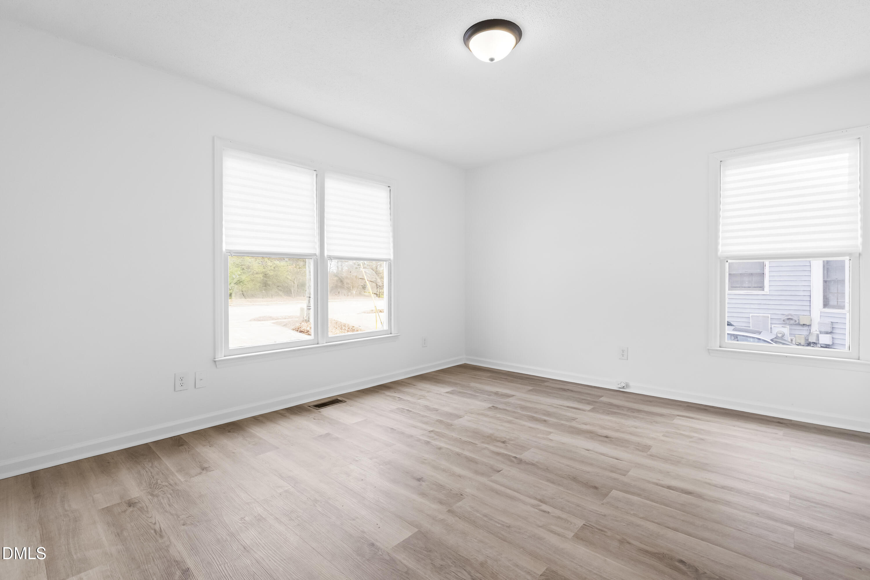 8029 Perry Creek Road Raleigh, NC 27616 - Photo 6 of 27 an empty room with wooden floor and windows
