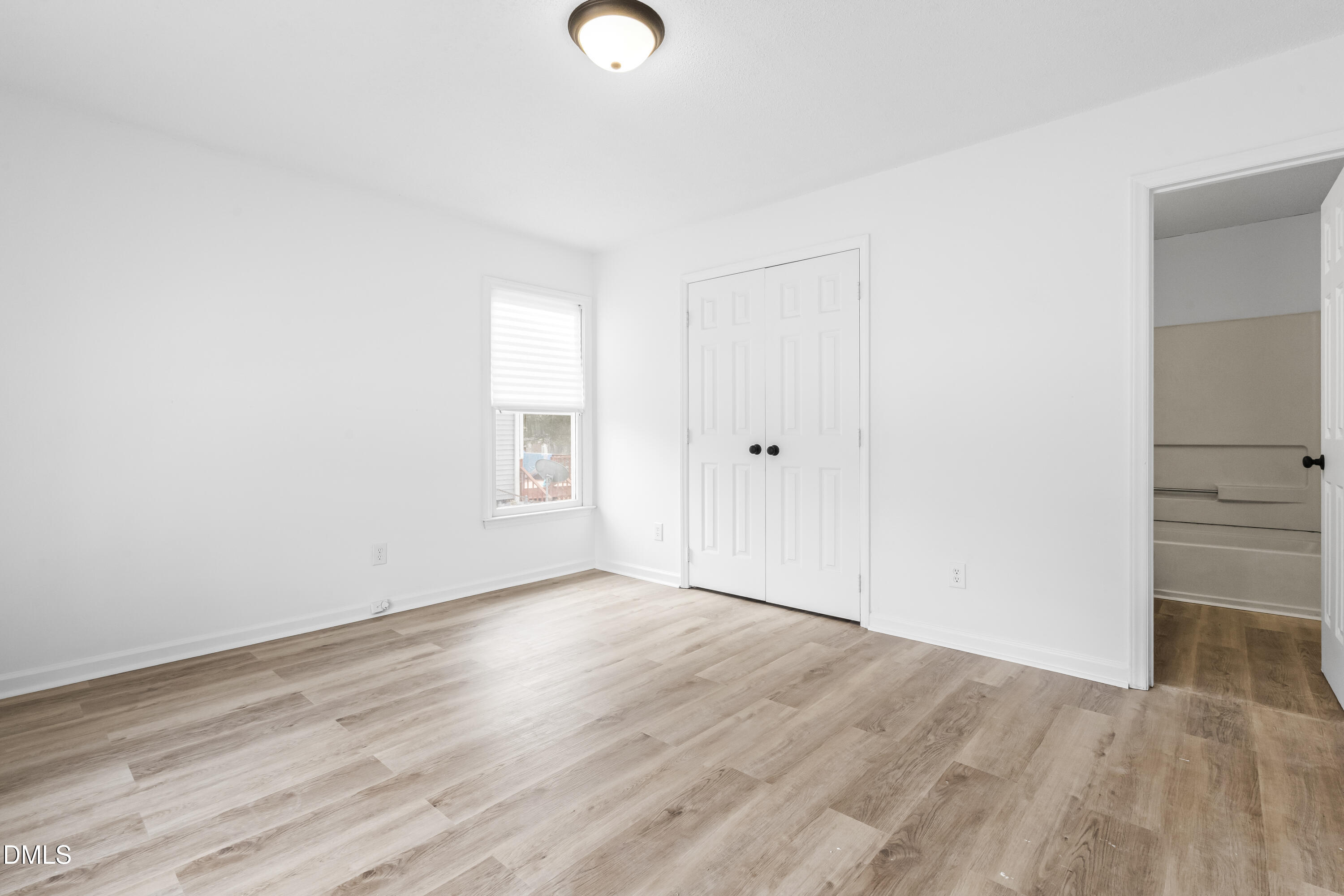 8029 Perry Creek Road Raleigh, NC 27616 - Photo 7 of 27 an empty room with wooden floor and windows