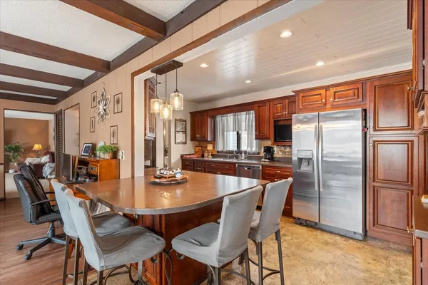 a dining room with stainless steel appliances granite countertop a dining table and chairs