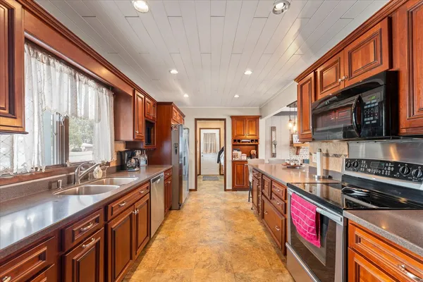 a large kitchen with stainless steel appliances granite countertop a large stove sink and cabinets