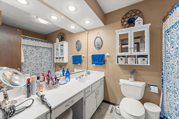 a bathroom with a sink a toilet and a large mirror