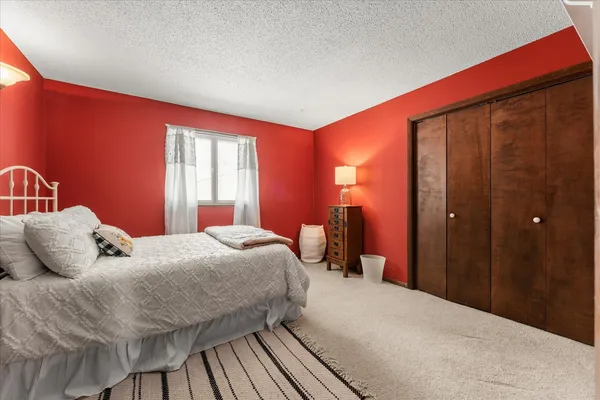 a bedroom with a bed and large windows