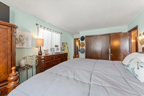 a large bedroom with a large bed and wooden floor