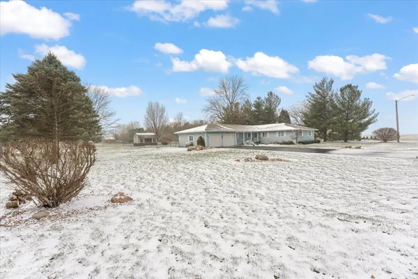a front view of house with yard and trees around