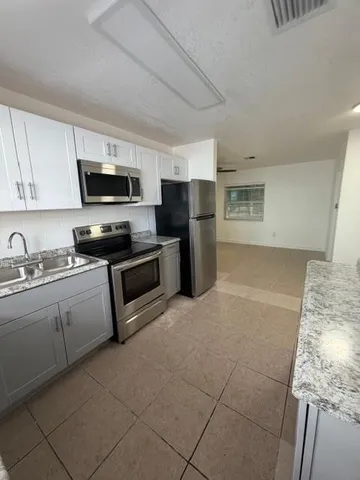 a kitchen with a sink a microwave and refrigerator