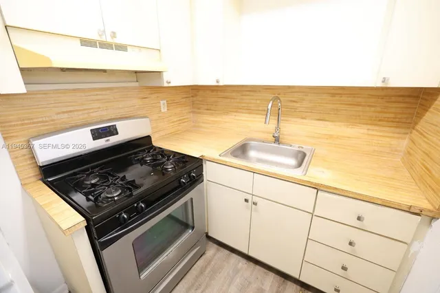 a kitchen with stainless steel appliances granite countertop a stove and a sink