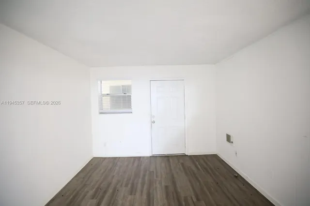 a view of an empty room with wooden floor