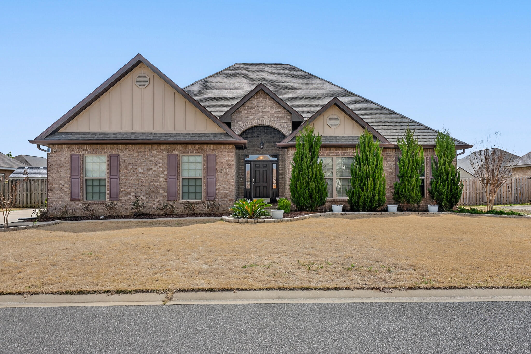 a front view of house with yard and trees in the background