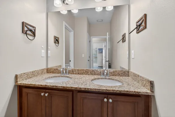a bathroom with a granite countertop sink a mirror and shower