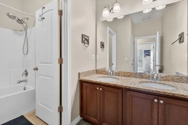 a bathroom with a granite countertop sink a large mirror and a bathtub