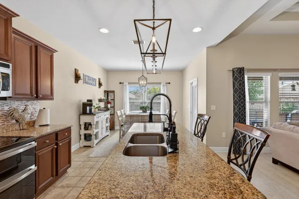 a living room with furniture a dining table and a chandelier