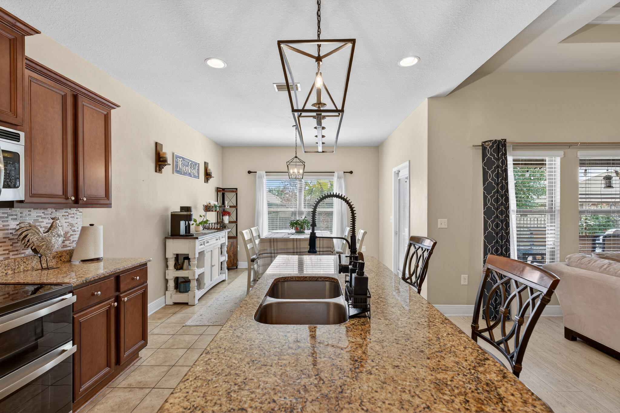 511 Gadwell Street Crestview, FL 32539 - Photo 29 of 48 a living room with furniture a dining table and a chandelier