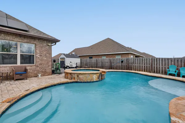 a view of a house with swimming pool and sitting area