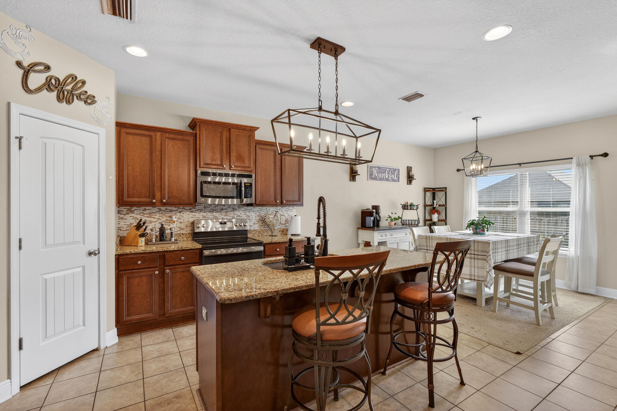 511 Gadwell Street Crestview, FL 32539 - Photo 8 of 48 a view of kitchen with granite countertop stools a sink a counter space and stainless steel appliances