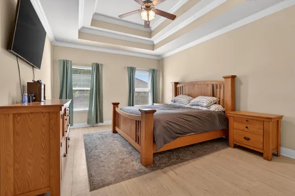 a bedroom with a bed and a flat tv screen on dresser