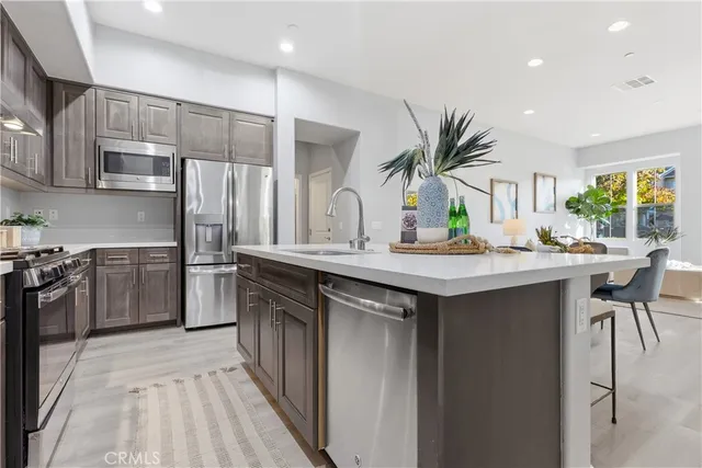a kitchen with stainless steel appliances a sink cabinets and a refrigerator