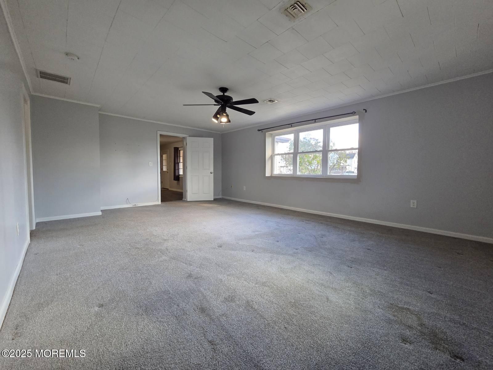 219 Dock Street Union Beach, NJ 07735 - Photo 12 of 22 an empty room with windows and chandelier fan