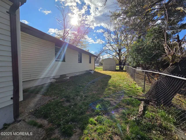 a view of a yard with wooden fence and large tree