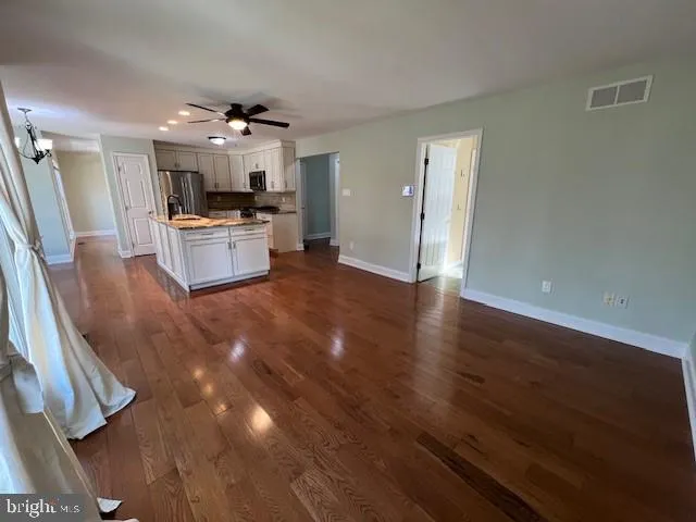 a open kitchen with cabinets a sink and appliances