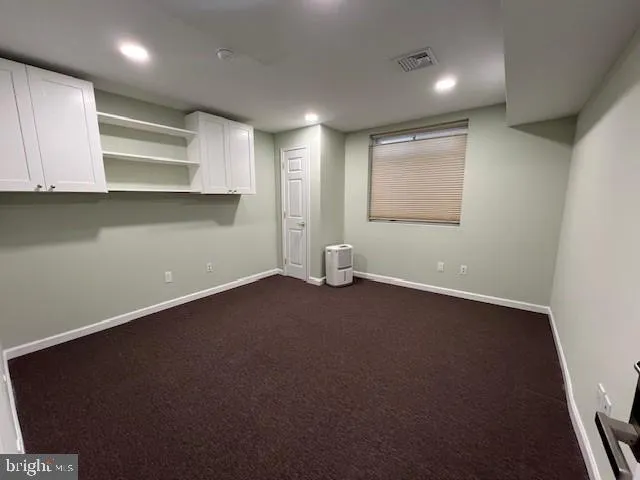 an empty room with a fireplace and wooden floor