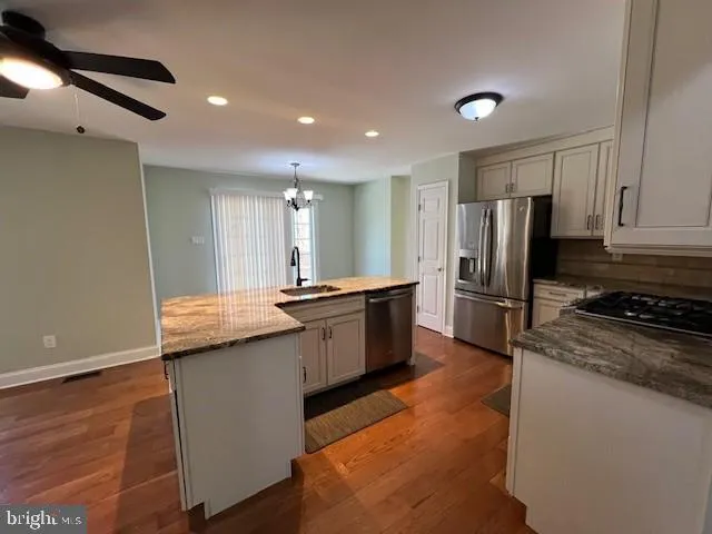 a large kitchen with a large window and stainless steel appliances