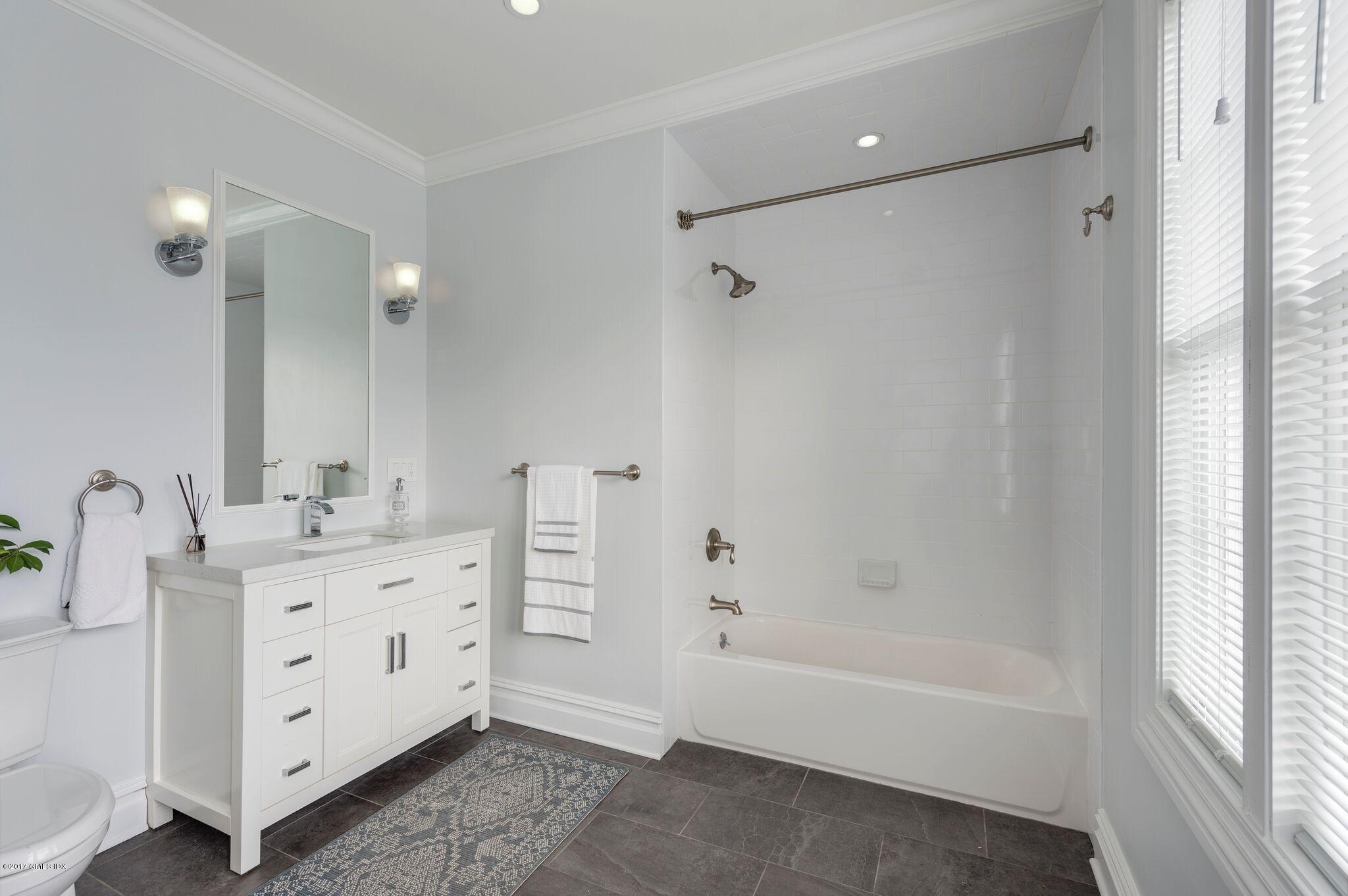 69 Circle Drive Greenwich, CT 06830 - Photo 13 of 21 a bathroom with a bathtub sink vanity and mirror