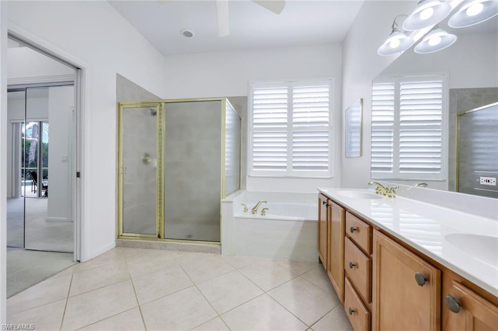 9375 Oak Strand Drive Estero, FL 34135 - Photo 16 of 30 a spacious bathroom with a granite countertop sink a mirror and a bathtub