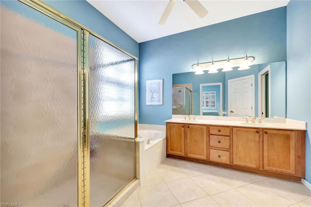 9375 Oak Strand Drive Estero, FL 34135 - Photo 17 of 32 Full bath with a garden tub, tile patterned flooring, a sink, and a shower stall