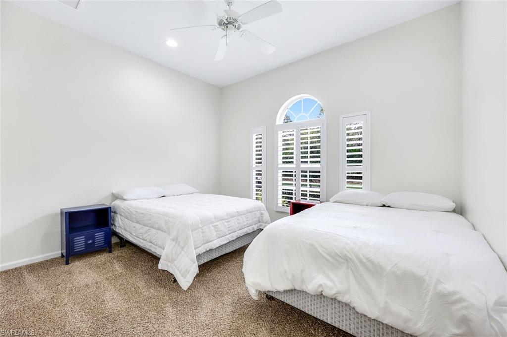 9375 Oak Strand Drive Estero, FL 34135 - Photo 19 of 30 a bedroom with a bed and a chandelier