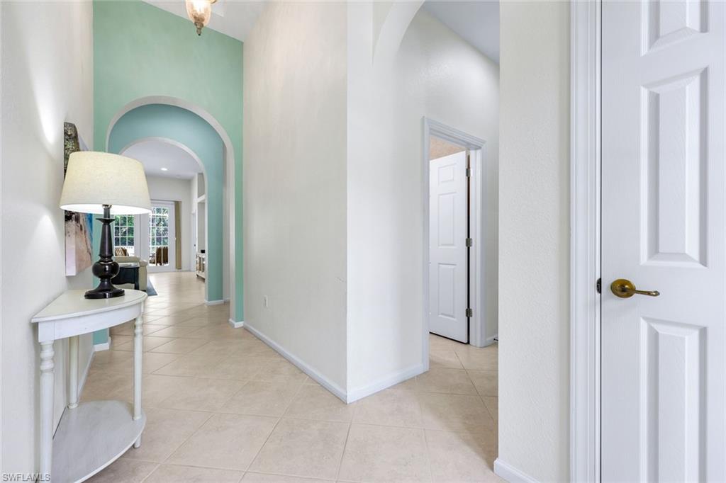 9375 Oak Strand Drive Estero, FL 34135 - Photo 4 of 30 Corridor featuring light tile patterned floors, baseboards, and arched walkways