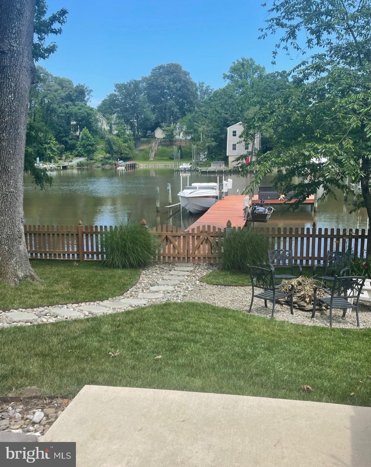 787 Powhatan Beach Road Pasadena, MD 21122 - Photo 12 of 12 a view of a lake with a garden and a bench in the background