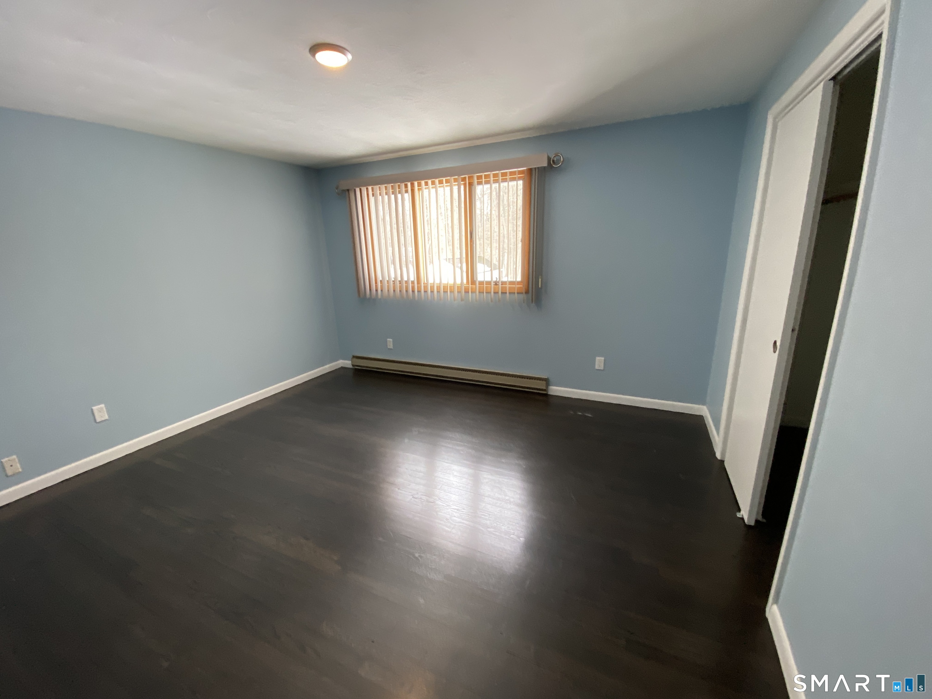 36 Corey Road North Haven, CT 06473 - Photo 9 of 25 an empty room with wooden floor and windows with curtains