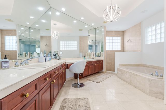 a spacious bathroom with a double vanity sink a mirror and a bathtub