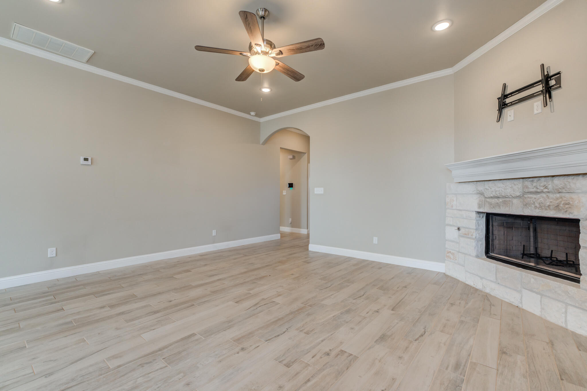 7633 87th Street Lubbock, TX 79424 - Photo 15 of 47 a view of an empty room with a fireplace and a chandelier fan