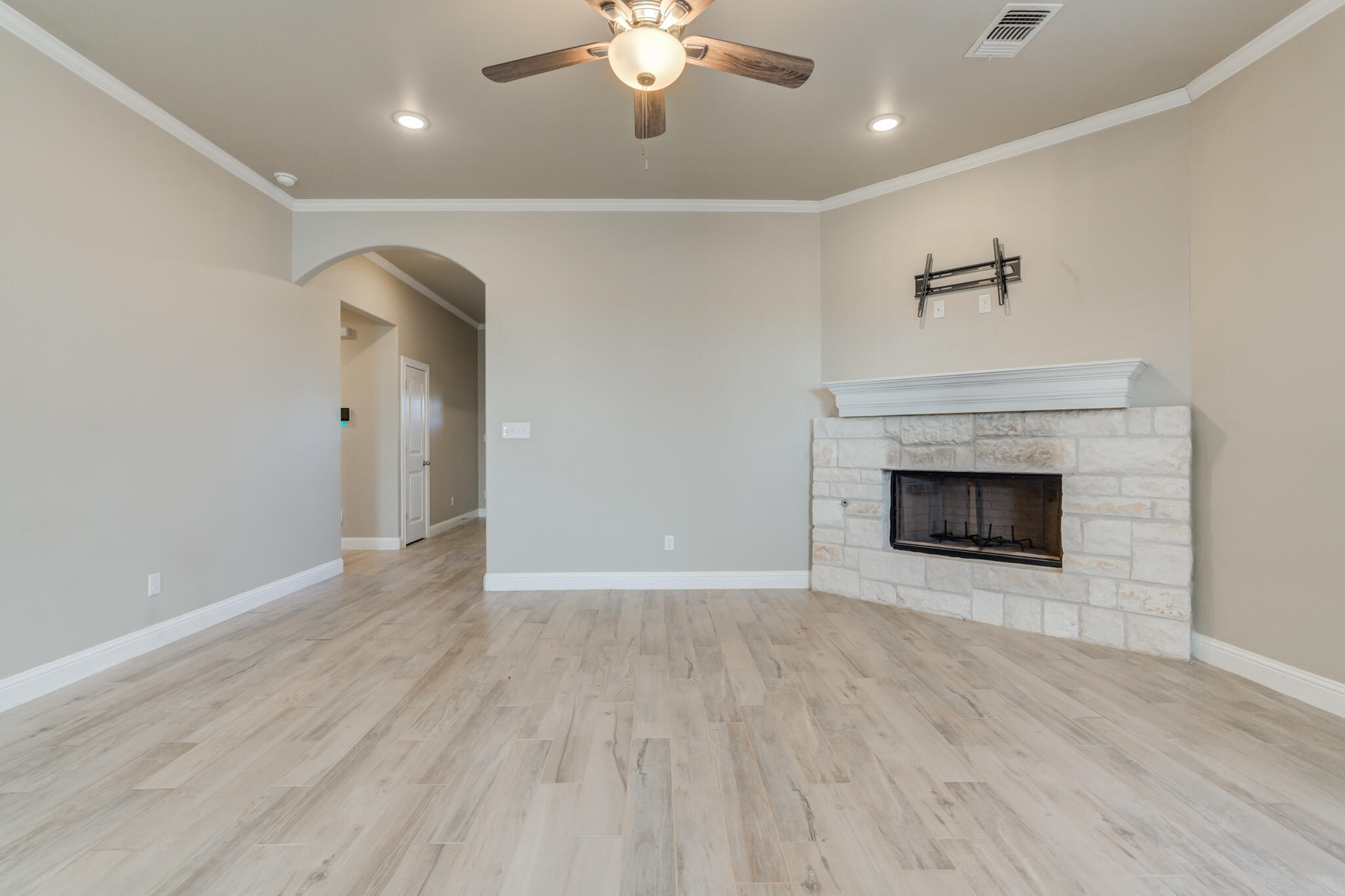 7633 87th Street Lubbock, TX 79424 - Photo 16 of 47 a view of an empty room with wooden floor fireplace and a window