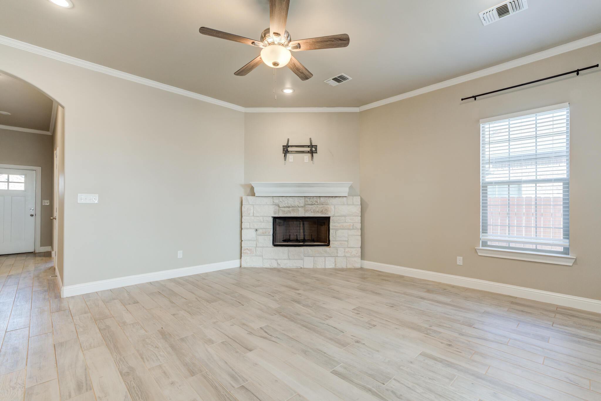 7633 87th Street Lubbock, TX 79424 - Photo 17 of 47 a view of an empty room with a fireplace and a window