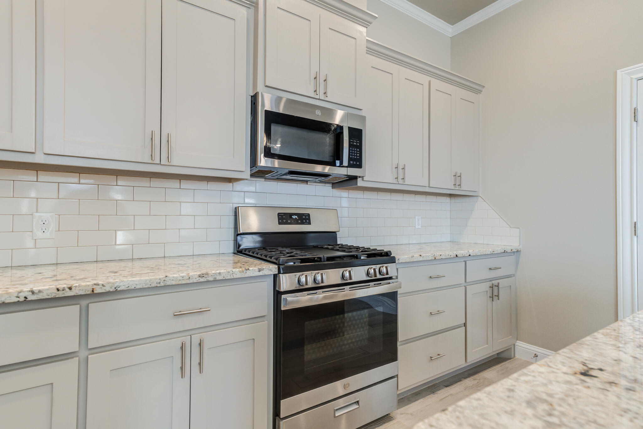 7633 87th Street Lubbock, TX 79424 - Photo 23 of 47 a kitchen with granite countertop white cabinets and stainless steel appliances