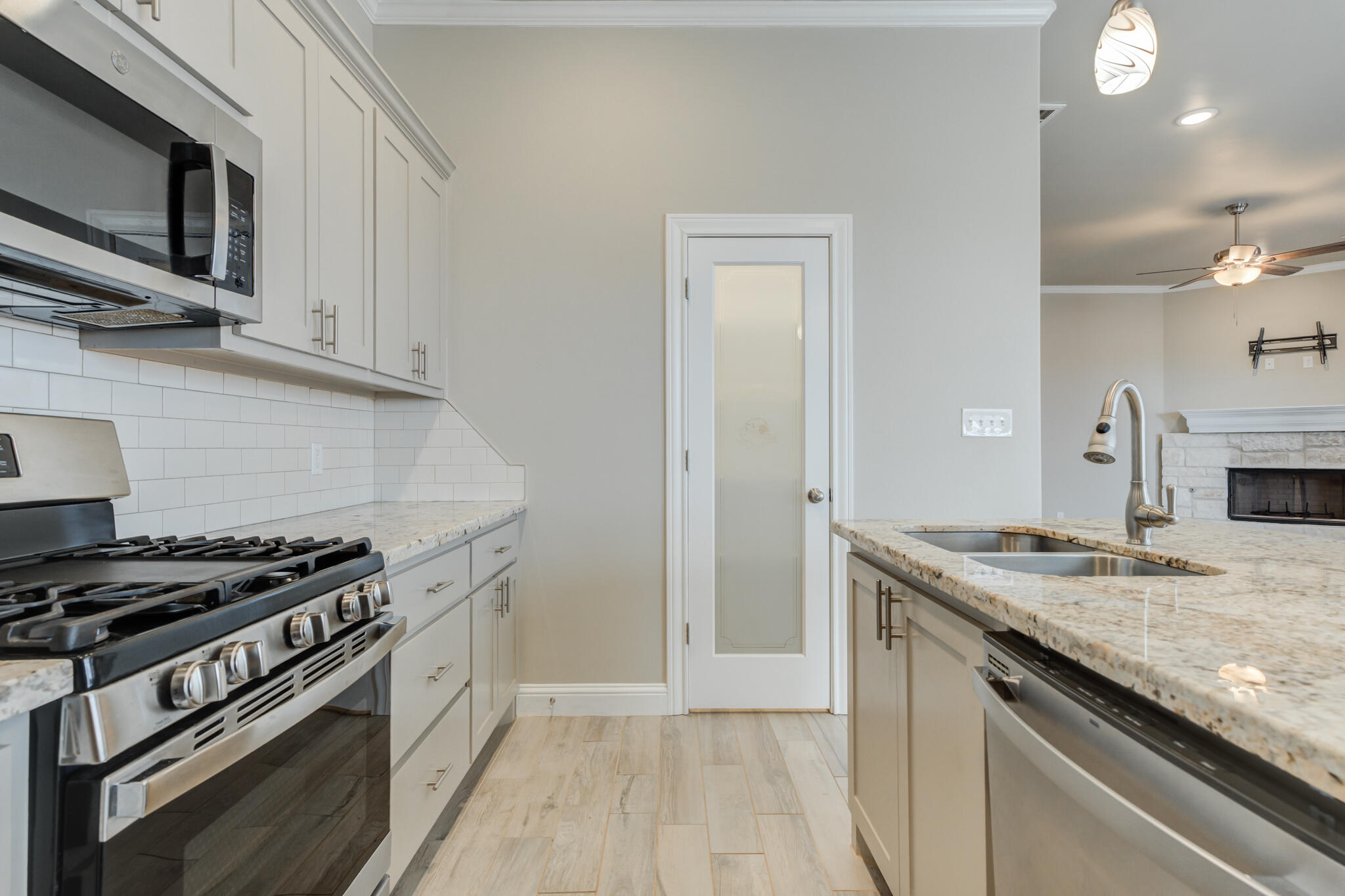 7633 87th Street Lubbock, TX 79424 - Photo 24 of 47 a kitchen with granite countertop a sink cabinets and stainless steel appliances