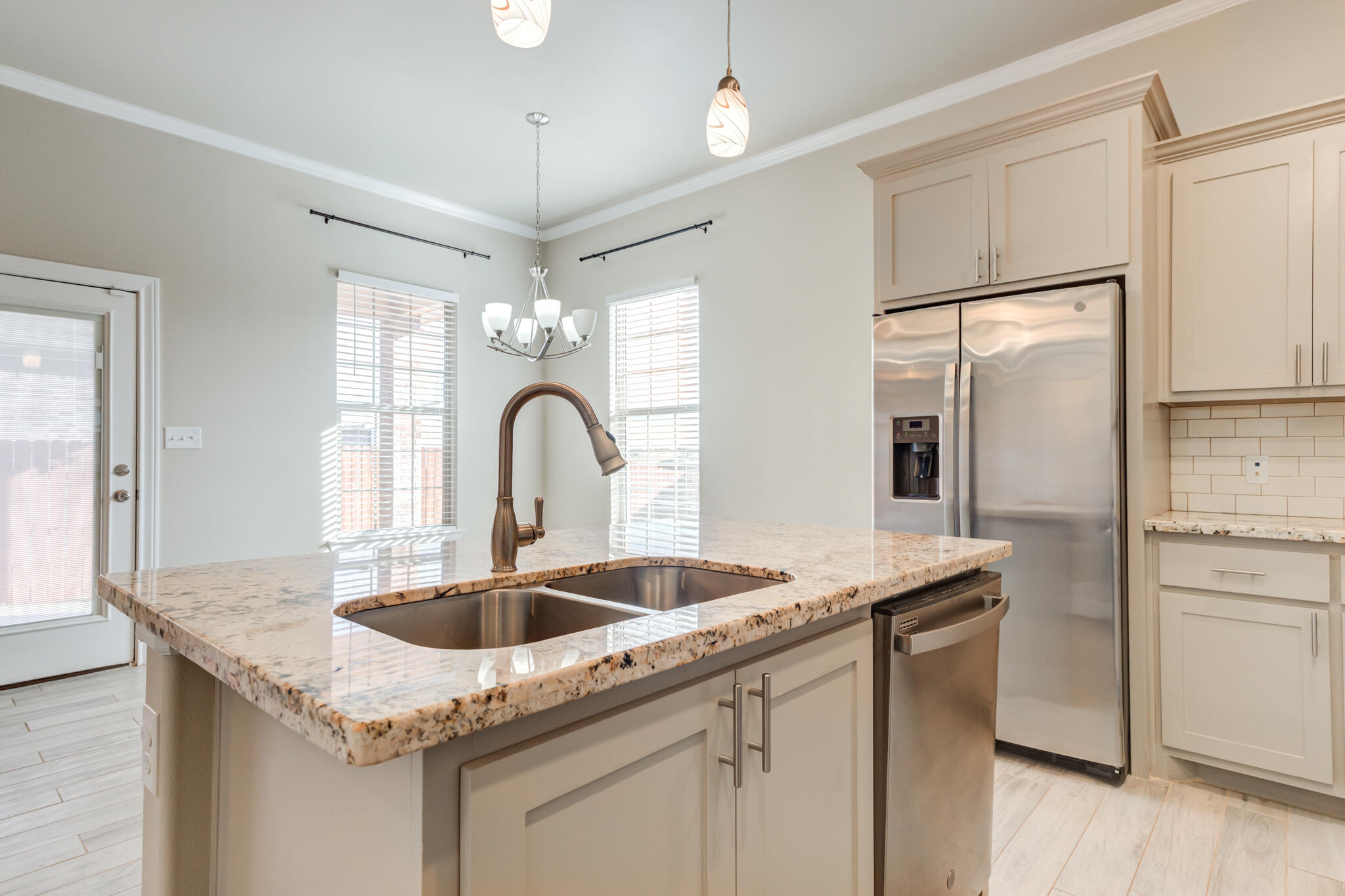 7633 87th Street Lubbock, TX 79424 - Photo 25 of 47 a kitchen with granite countertop a sink and refrigerator