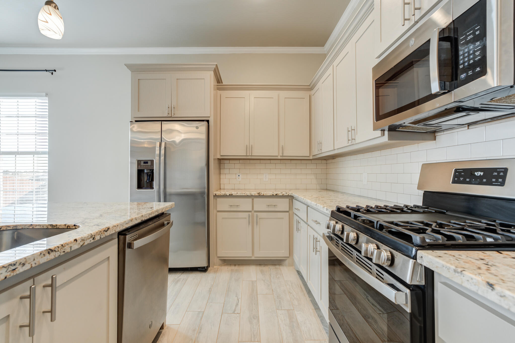 7633 87th Street Lubbock, TX 79424 - Photo 26 of 47 a kitchen with stainless steel appliances granite countertop a stove a sink and a refrigerator