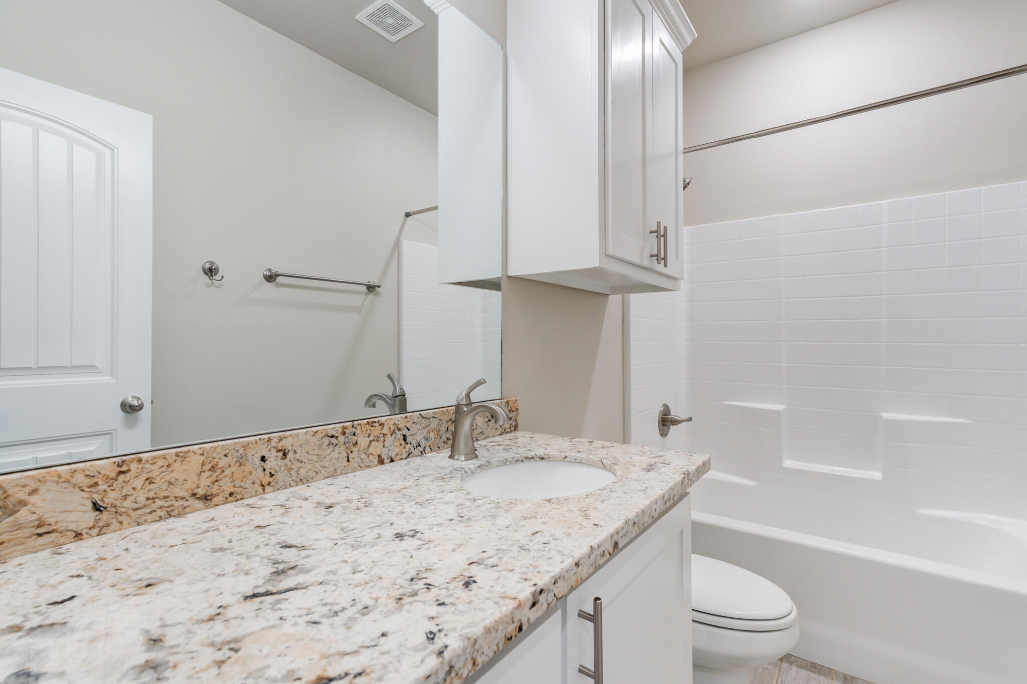 7633 87th Street Lubbock, TX 79424 - Photo 29 of 47 a bathroom with a granite countertop sink a toilet and bathtub