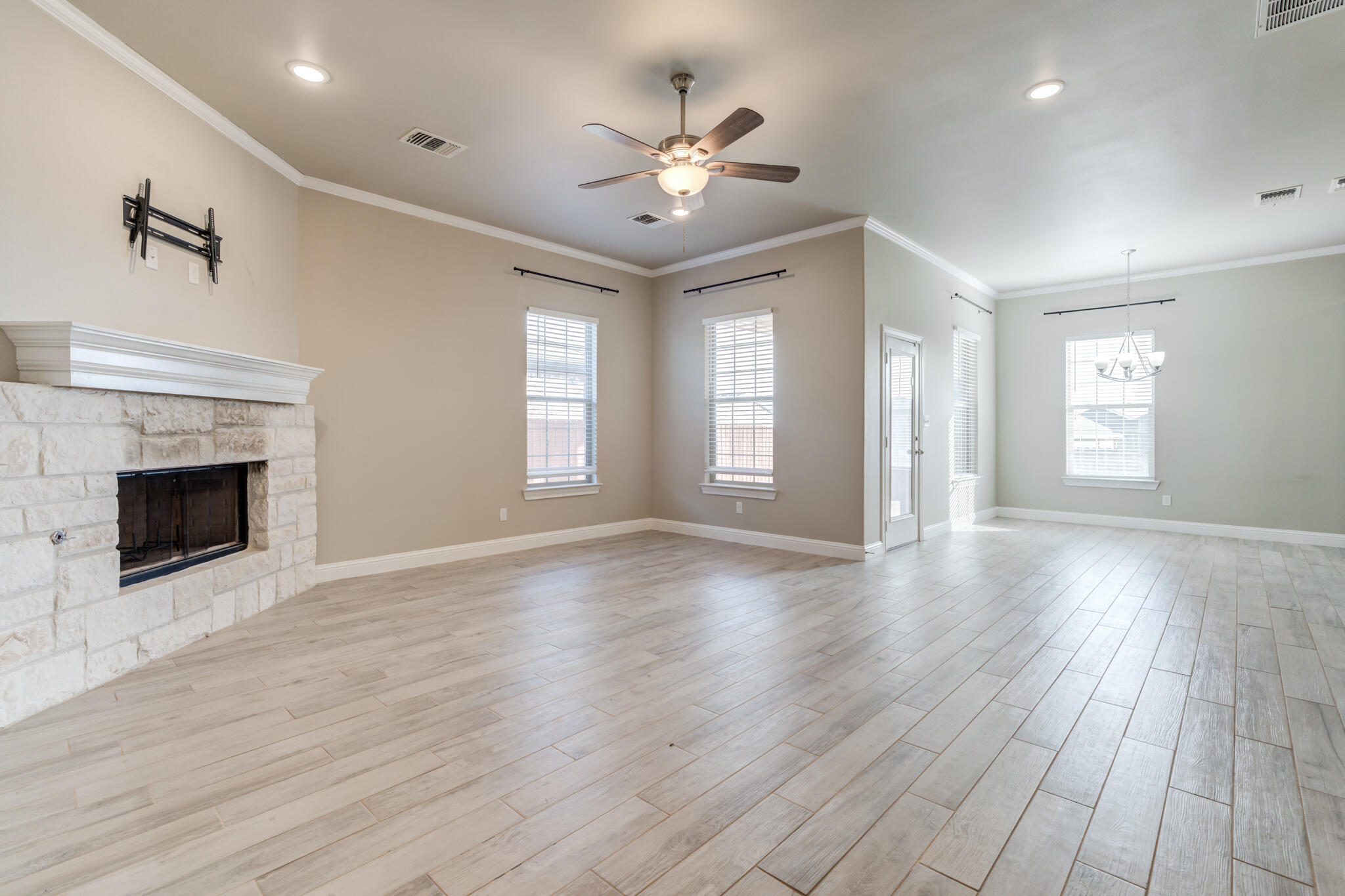 7633 87th Street Lubbock, TX 79424 - Photo 3 of 47 an empty room with wooden floor fireplace and windows