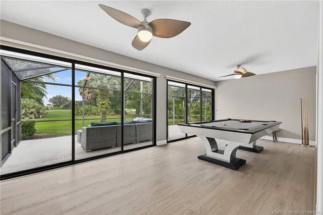 a living room with a floor to ceiling window and wooden floor