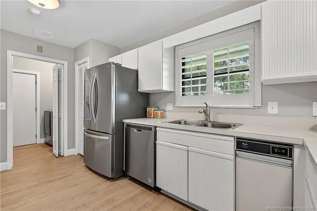 a kitchen with stainless steel appliances a refrigerator sink and cabinets