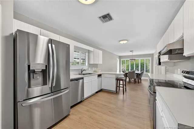 a kitchen with stainless steel appliances granite countertop a refrigerator stove microwave and sink