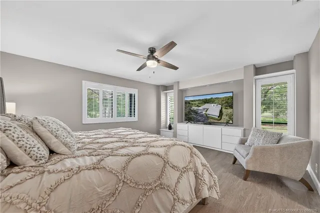 a bedroom with a large bed couch and window